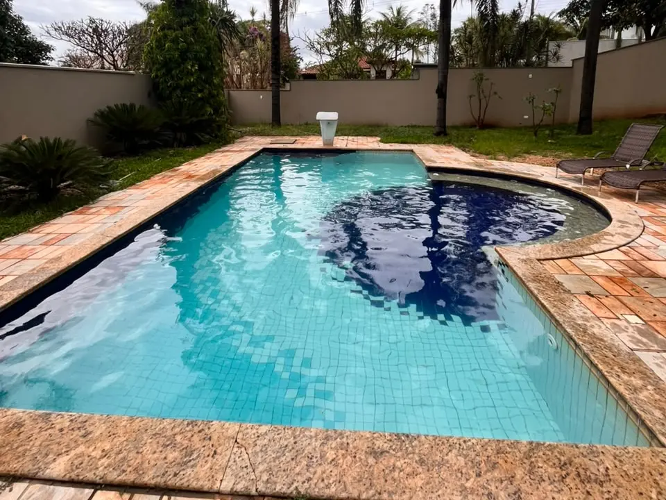 Piscina de pastilha azul limpa, com coqueiros ao fundo